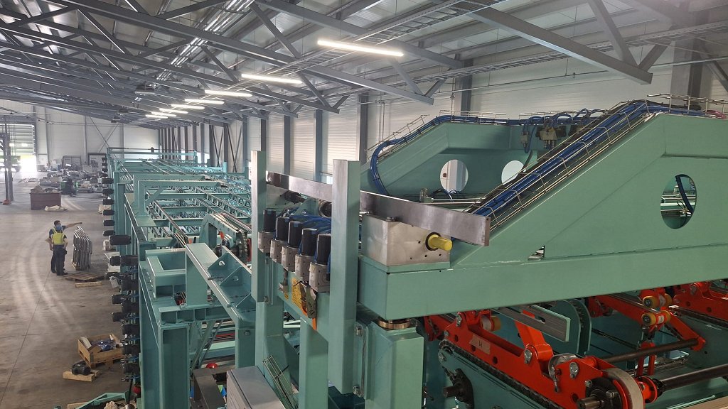 Vrhunska slovenska tehnologija ob Baltiku Ledinek Engineering soustvarja napredek lesene gradnje v Latviji. Na fotografiji linija za izdelavo konstrukcijskih gradbenih letev.